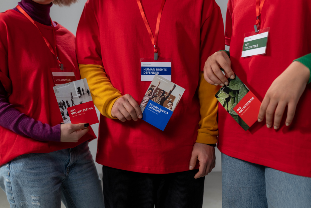 an image of 3 people holding up branded brochures - an example of offline marketing